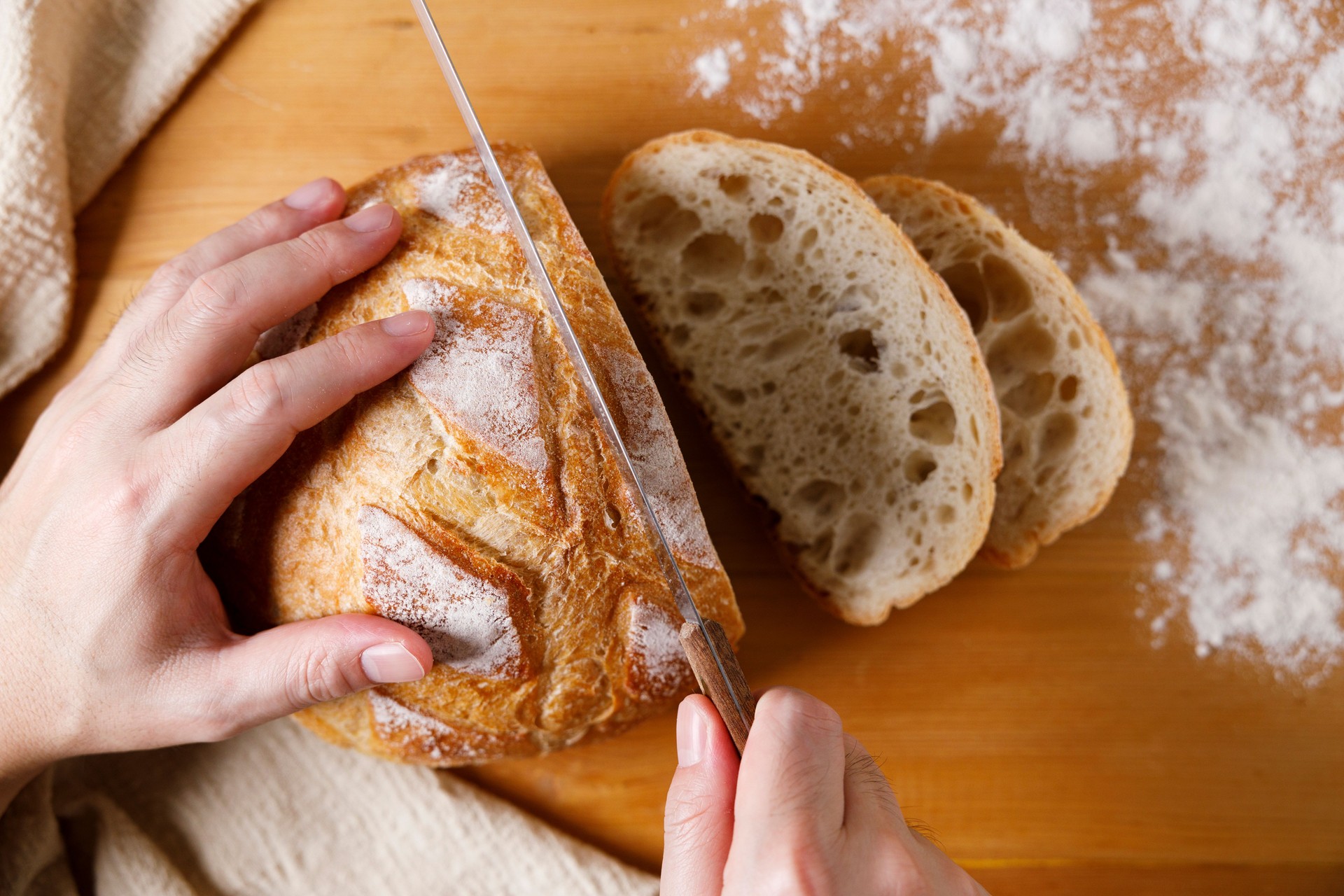 Closeup of rustic bread loaf on wooden table.